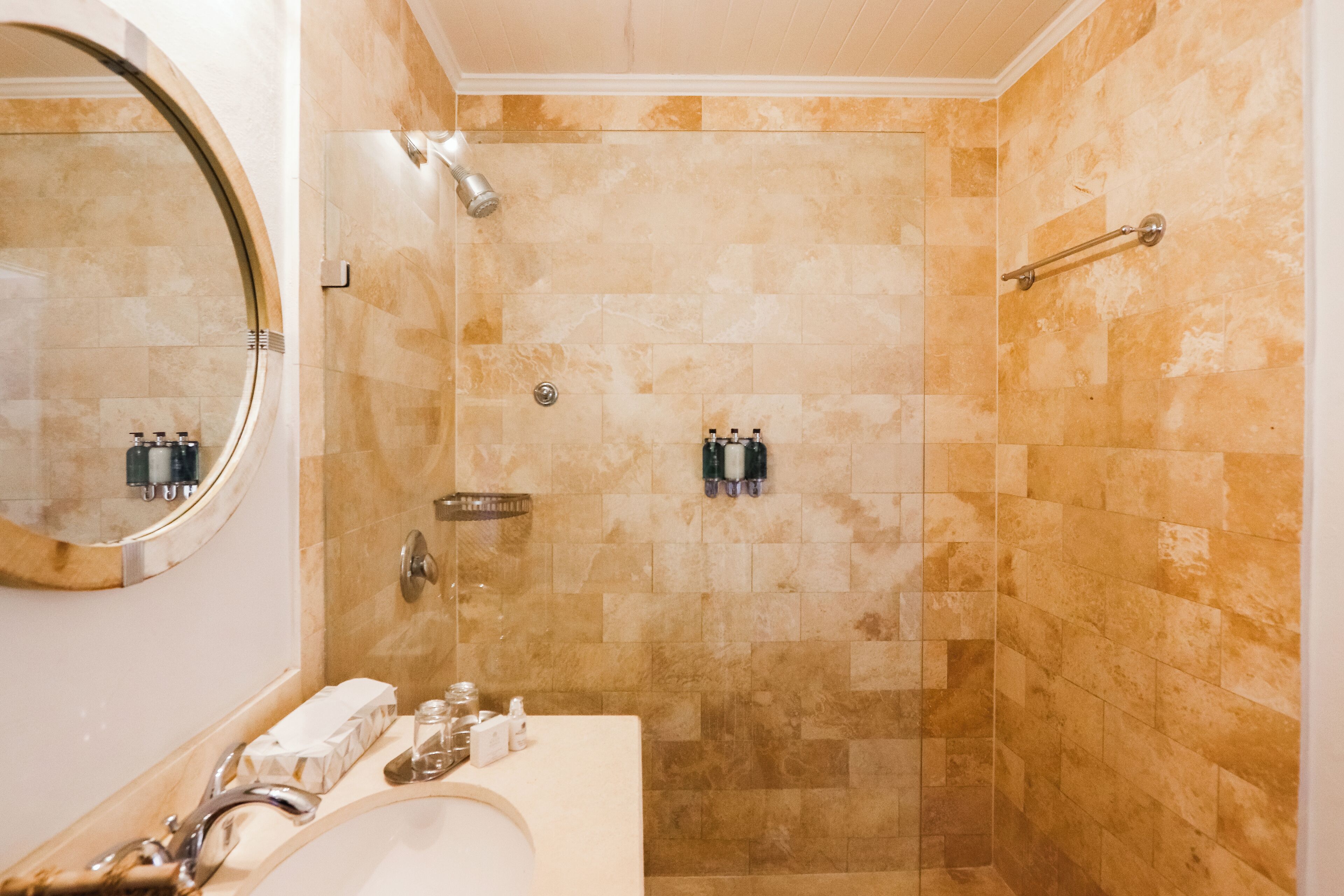 Un bagno con doccia, lavandino e specchio.