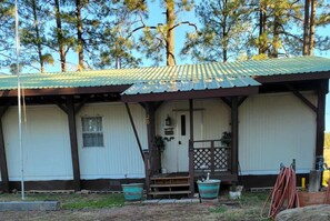 A single-story building with a metal roof, a front door, and a small porch area.