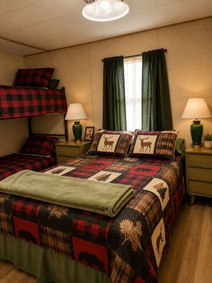 A room with a bunk bed, two bedside tables with lamps, a window with curtains, and a quilt with animal prints. - Quiet Escape for Hunters & Family Retreats! (Alpine)