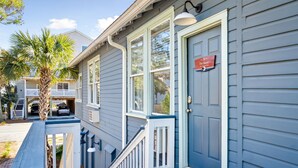 A two-story house with a blue exterior, white trim, and a front porch. - Folliday Inn - The Racer - Room 35 (Folly Beach)