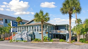 A two-story building with a balcony, palm trees, and a sign for 'Holiday Inn'. - Folliday Inn - The Triple - Room 24 (Folly Beach)