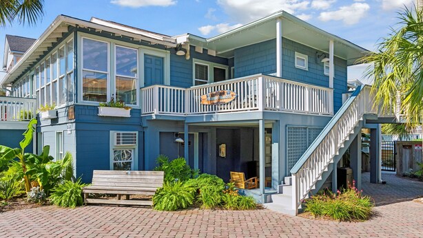 A two-story house with a balcony, a staircase, and a front porch. - Folliday Inn - The Triple - Room 24 (Folly Beach)