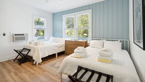 A bedroom with two beds, a ceiling fan, a wooden dresser, and a window with blinds. - Folliday Inn: Room: The Dolphin: Room 36 (Folly Beach)