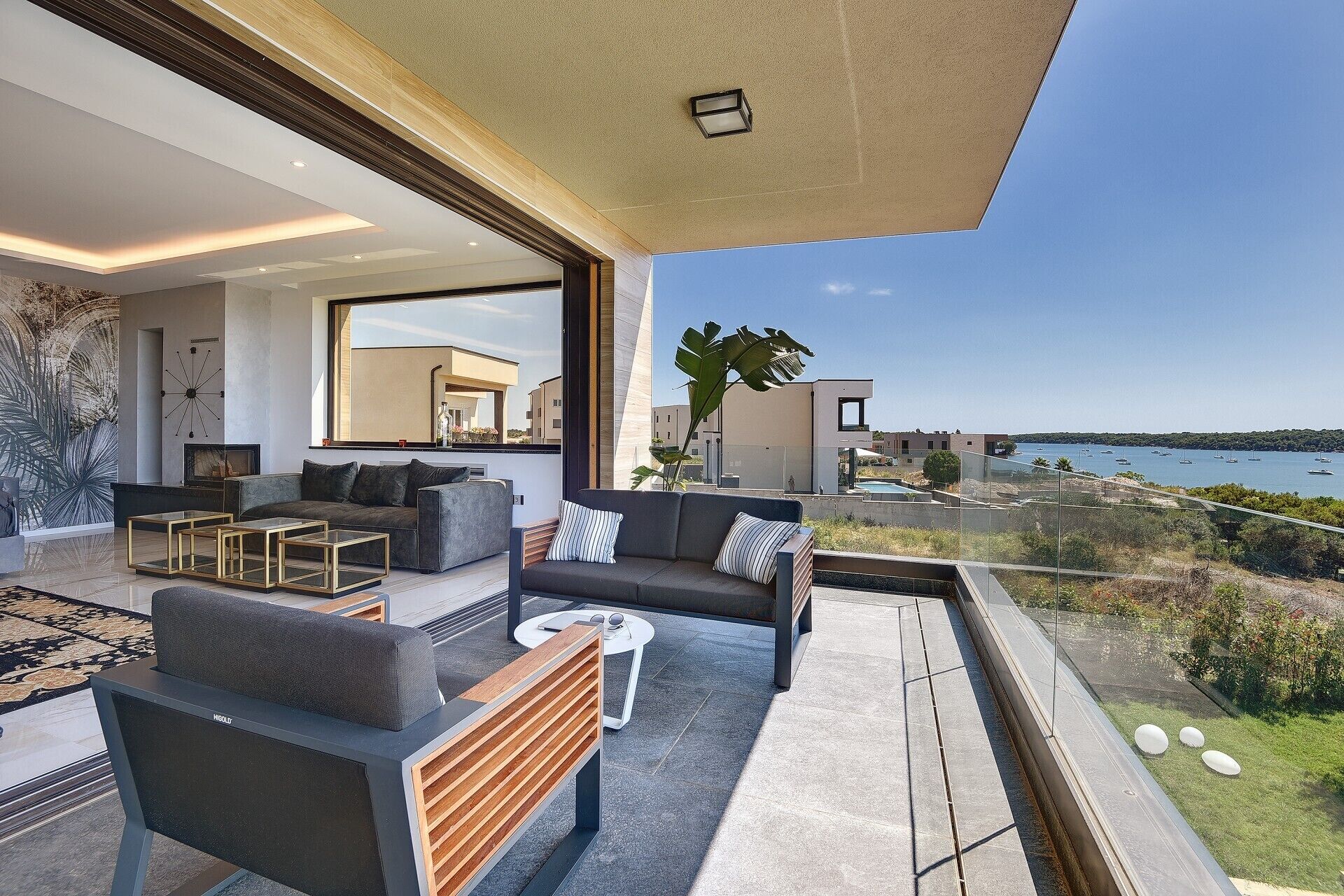 Un salón moderno con un ventanal grande que ofrece vistas panorámicas de la costa.