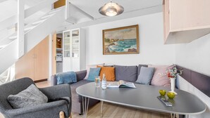 A modern living room with a grey sofa, a small table, and a staircase. - Awesome apartment in Allinge with WiFi (Allinge)