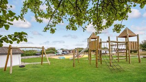 A playground with a swing set, climbing structures, and a slide. - Awesome apartment in Allinge with WiFi (Allinge)