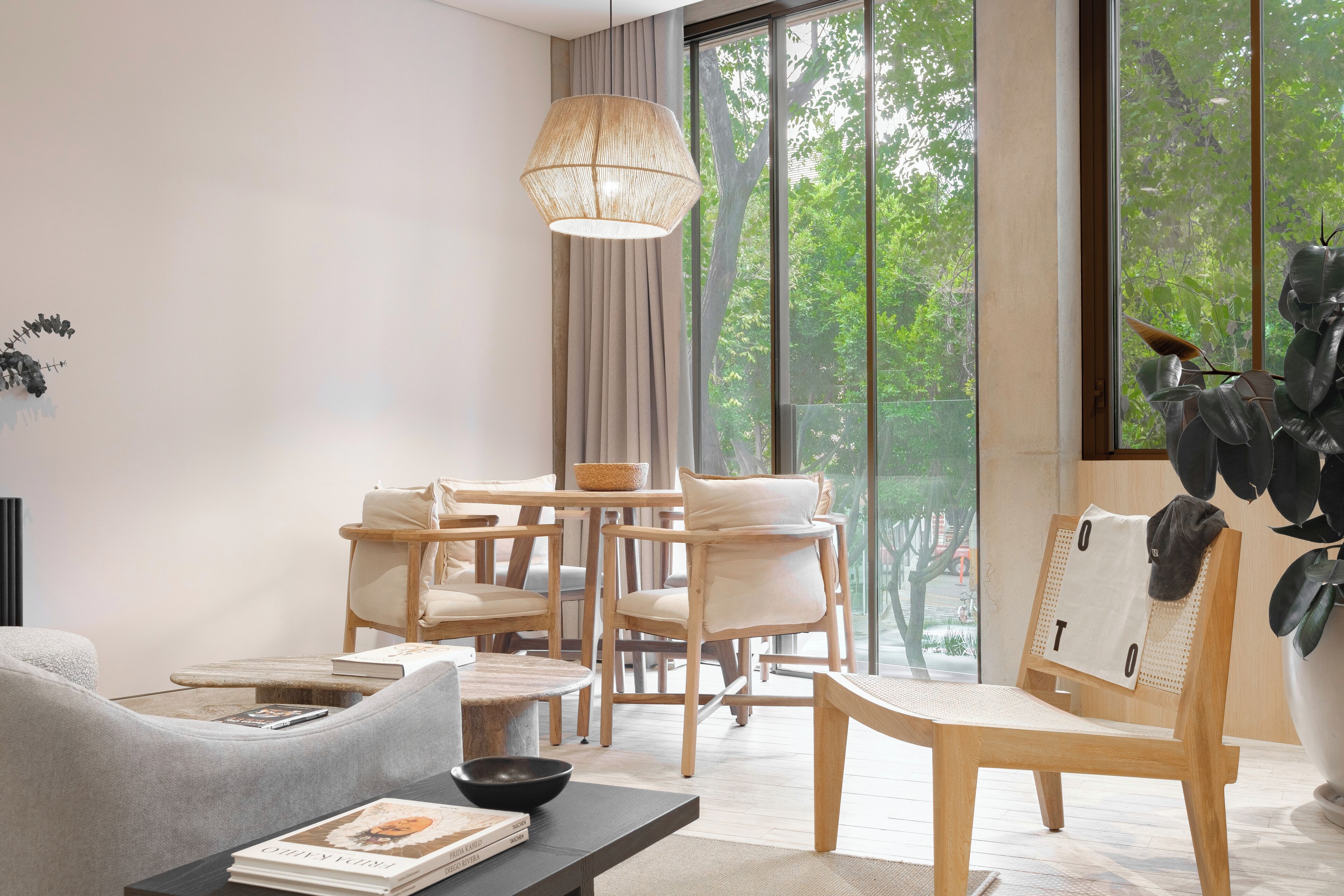 Una sala moderna con un ventanal grande, una mesa de comedor de madera y asientos cómodos.