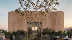 An outdoor patio area with a wooden wall, seating, and potted plants. - ONTO Tonalá Mexico City (Mexico City)