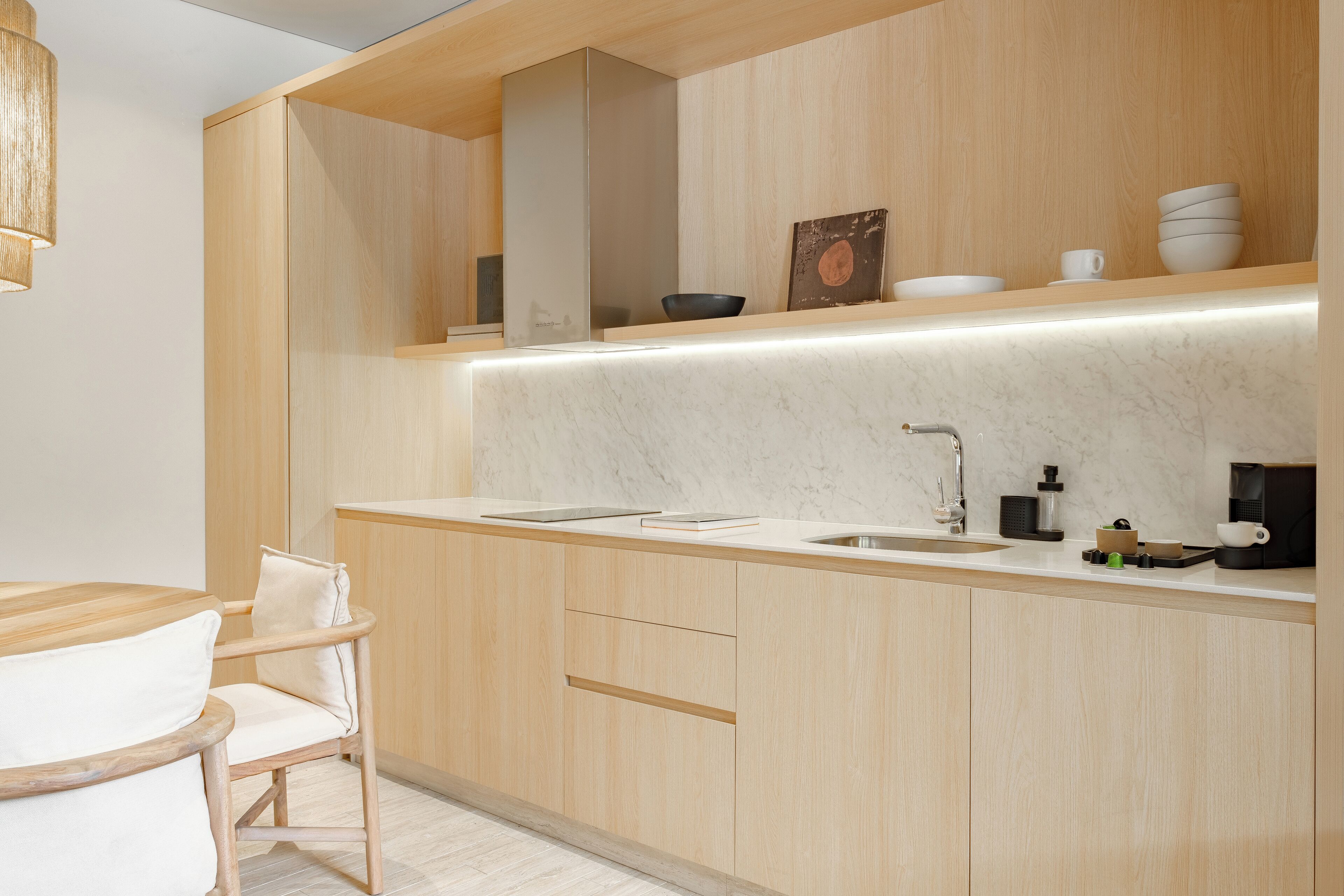 Une cuisine moderne avec des meubles en bois, un plan de travail en marbre et un évier encastré.