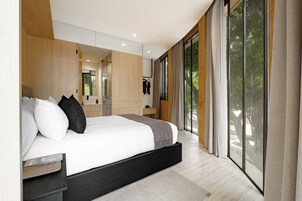 Une chambre à coucher moderne, dotée d’un grand lit, d’une table de chevet, d’un miroir et offrant une vue sur l’extérieur grâce à de grandes fenêtres.