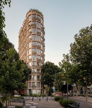 A modern, multi-story building with a curved facade, surrounded by lush greenery and a pedestrian walkway. - ONTO Tonalá Mexico City (Mexico City)