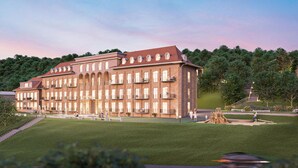 A large, multi-story building with a symmetrical facade, multiple balconies, and a central courtyard with a playground. - Apartment Blankenburg (Bad Frankenhausen)