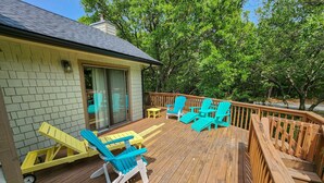 Um deck de madeira com móveis de exterior, incluindo cadeiras e uma mesa.