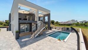 A modern two-story house with a swimming pool, outdoor seating, and a staircase leading to the upper floor. - Beautiful apartment in Sukosan (Sukosan)