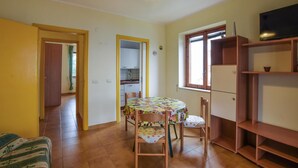 A compact living space with a dining area, kitchen, and a TV. - Stunning apartment in Nocera Terinese (Nocera Terinese)