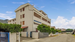 A multi-story building with a flat roof, a balcony on the second floor, and a gated entrance. - Stunning apartment in Nocera Terinese (Nocera Terinese)