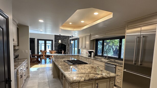 A spacious kitchen with a large island, granite countertops, and stainless steel appliances.