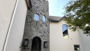 A building with a stone facade, a black door, and a small window.