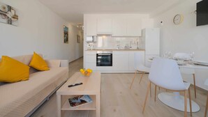 Una sala de estar moderna con un sofá, una mesa de centro y un comedor con una mesa y sillas.