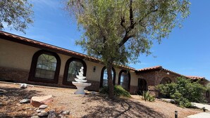 A building with arched windows, a stone facade, and a fountain. - Perfectly located amazing private single story home. (Las Vegas)