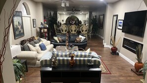 A spacious living room with a dark-colored sofa set, a coffee table, and a fireplace. - Perfectly located amazing private single story home. (Las Vegas)
