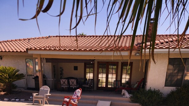 A swimming pool with a tiled deck, lounge chairs, and a covered patio area. - Perfectly located amazing private single story home. (Las Vegas)