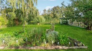 Um jardim bem cuidado, com diversas plantas e um pequeno lago.