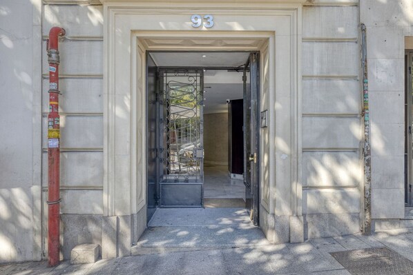Enter a charming building with a distinctive metal gate and a welcoming covered area.