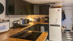 A compact kitchen with a wooden countertop, a sink, a stove, and a refrigerator. - Nice home in Follafoss with lake view (Follafoss)