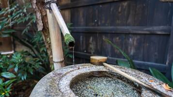 Una fontana in pietra con un beccuccio e un manico di legno.