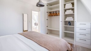Un dormitorio con una cama grande, un armario con espacio para colgar y vistas a un comedor.