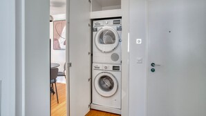 A laundry room with two stacked washing machines and a door leading to another room. - Nice Wallisellen 2br w/ Storage & W/D, nr Local Market, by Blueground (Zurich)