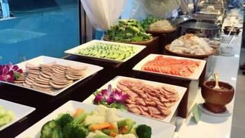 A buffet with various food items including vegetables, meats, and a variety of dishes.