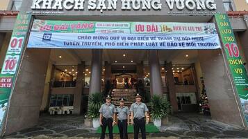 The entrance of Khach San Hung Vuong hotel with a banner advertising a 10% discount.