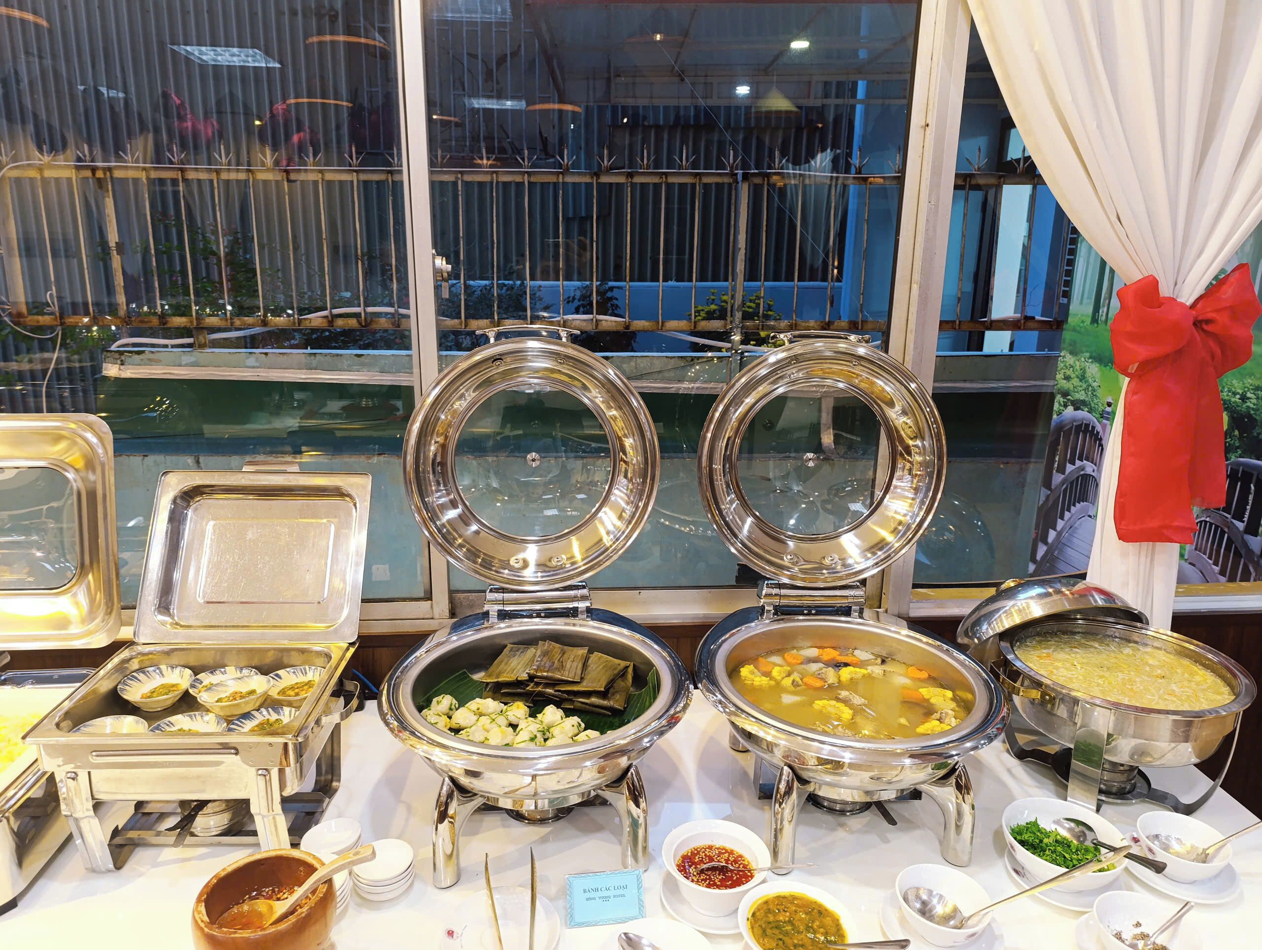 Een buffetopstelling met diverse voedselcontainers en bestek.