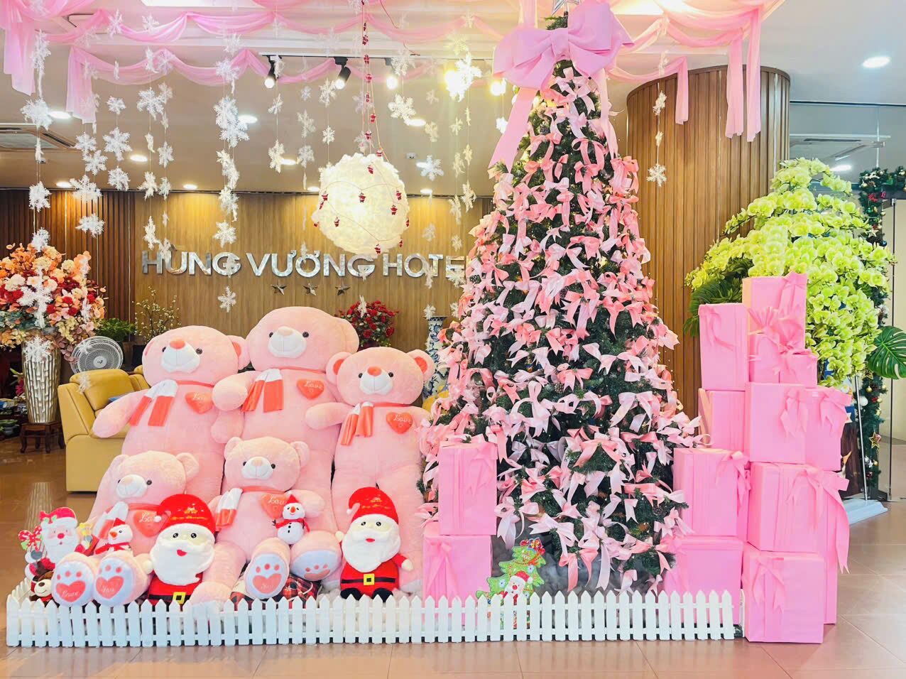 A hotel lobby decorated with a Christmas tree, teddy bears, and gift boxes.