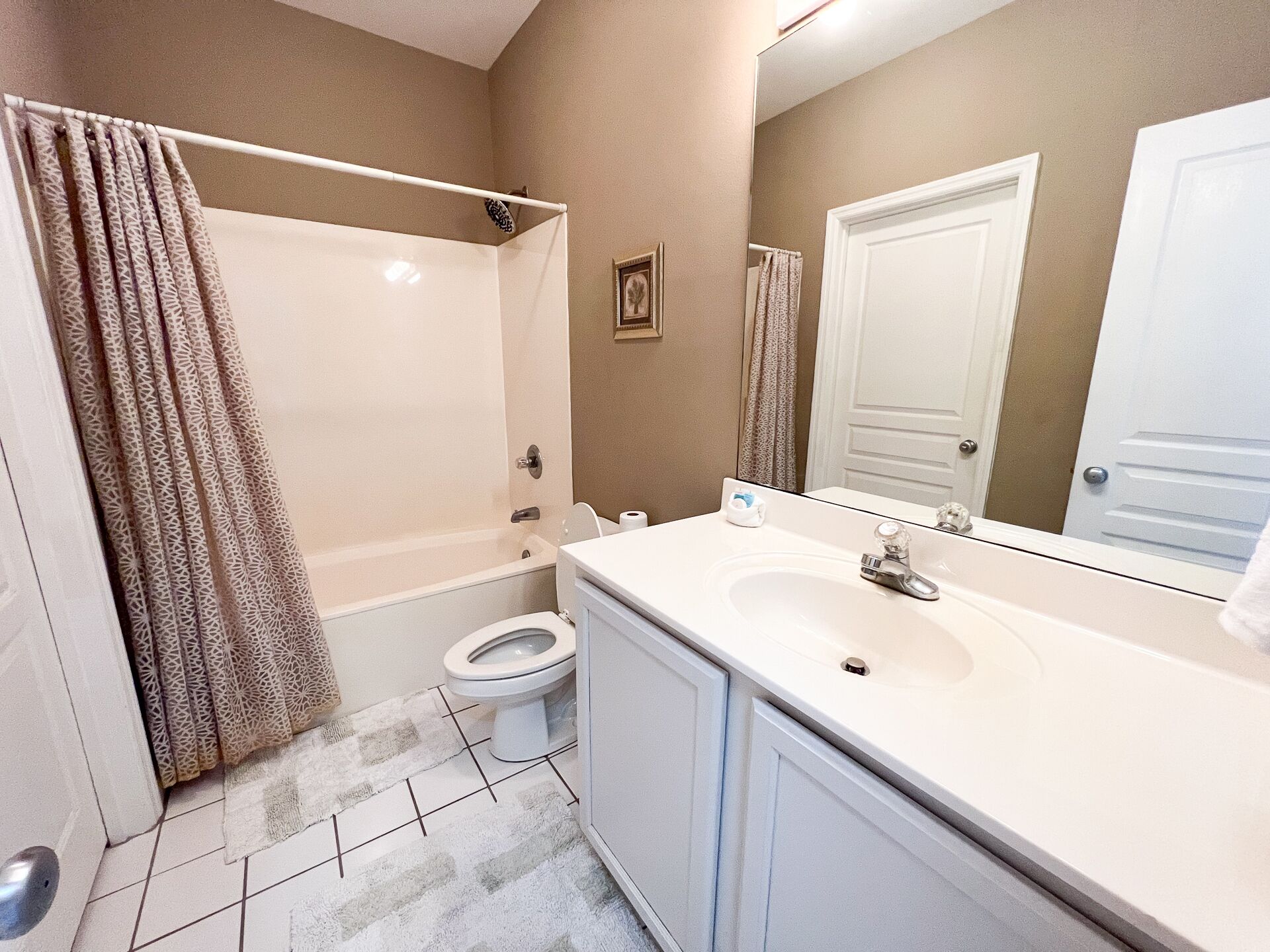A bathroom with a bathtub, toilet, and sink.