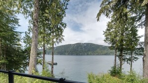 A lake with a dock, surrounded by trees and a mountain in the background.