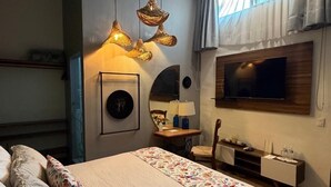 Un dormitorio moderno con una cama grande, un televisor montado en la pared y una lámpara de techo.