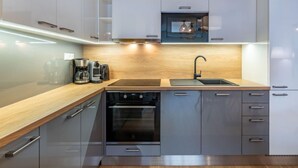 Una cucina moderna con un piano di lavoro in legno, elettrodomestici in acciaio inossidabile e forno integrato.