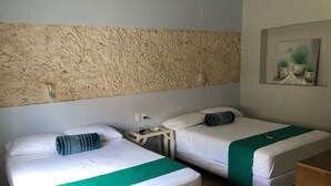 A hotel room with two beds, a textured wall, a painting, and a small table. - Casa Colonial en el Centro de Mérida, Remodelada, Excelente Para Grupos Grandes (Centro)
