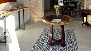 A spacious living area with a round wooden coffee table, a chandelier, and a patterned tile floor. - Casa Colonial en el Centro de Mérida, Remodelada, Excelente Para Grupos Grandes (Centro)