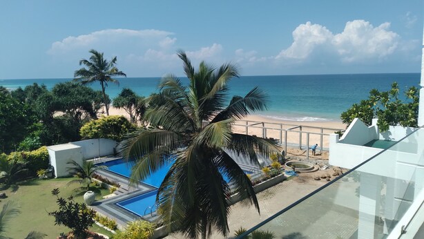 Zona de piscina con vista a la playa y al océano.