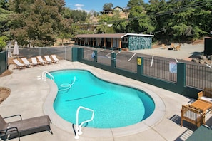Piscina com espreguiçadeiras e área de estar coberta.