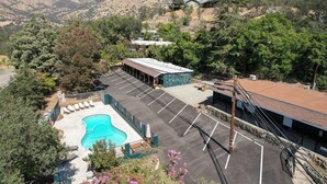 A hotel with a swimming pool, parking lot, and mountain views. - Moro RM3 Sequoia Motel- AC, Pool, WiFi, 10min SNP (Three Rivers)