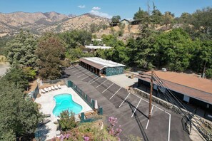 Ein Hotel mit Schwimmbad, Parkplatz und Bergblick.