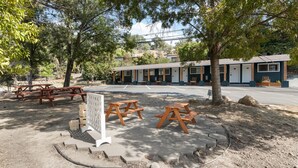 A motel with outdoor seating, a covered area, and a parking lot. - The Whitney Room 7 Sequoia Motel - Mins to Park! (Three Rivers)