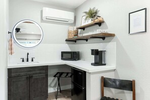 A compact kitchen with a white countertop, a black refrigerator, a microwave, a coffee maker, and a small stool. - Sequoia Motel King RM6, AC, Pool, WiFi 10 Min SNP (Three Rivers)