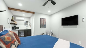 A bedroom with a large bed, a ceiling fan, a mounted TV, and a small desk area. - The Rae Sequoia Motel RM5 (Three Rivers)