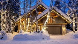 A snow-covered lodge with a garage, surrounded by trees. - Alpine chalet w/ AC, hot tub, media (Whistler)
